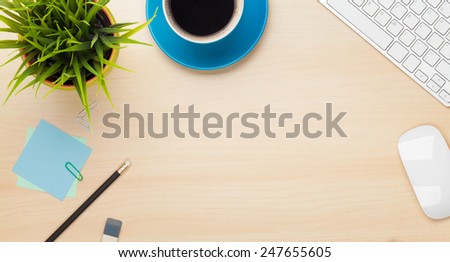 Office table with coffee cup, computer and flower. View from above with copy space