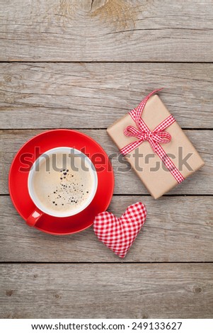 Valentines day gift box, toy heart and coffee cup over wooden table with copy space