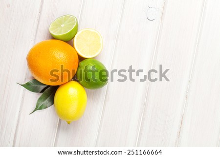 Citrus fruits. Oranges, limes and lemons. Top view over wooden table background with copy space