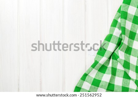 Green towel over wooden kitchen table. View from above with copy space