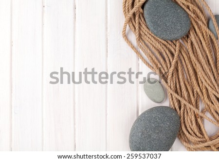 Wooden background with marine rope, sea stones and copy space