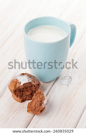 Cup of milk and cake on white wooden table