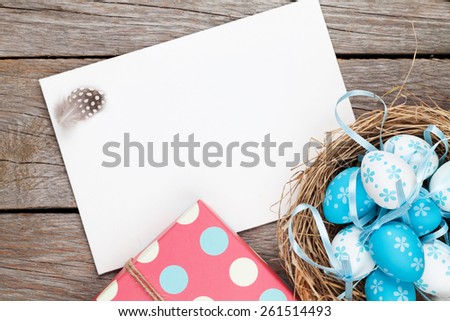 Easter greeting card with blue and white eggs and gift box over wood Top view with copy space Easter greeting card with blue and white eggs and gift box over wood Top view with copy space