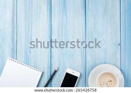 Coffee cup, smartphone and blank photo frame on wooden table background. Top view with copy space