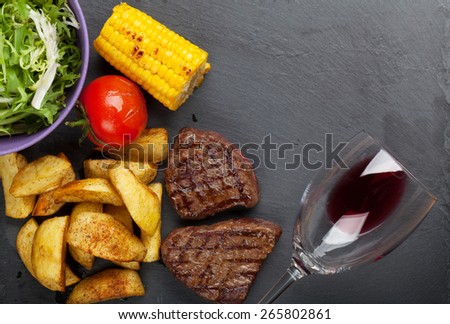 Beef steak with grilled potato, corn, salad and red wine. Top view with copy space