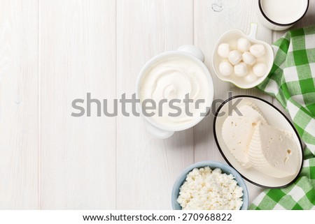 Dairy products on wooden table. Sour cream, milk, cheese, yogurt and butter. Top view with copy space