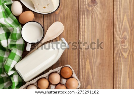 Dairy products on wooden table. Milk, cheese and eggs. Top view with copy space