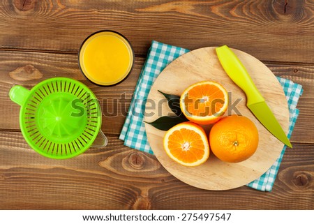 Orange fruits and glass of juice. Top view over wood table background