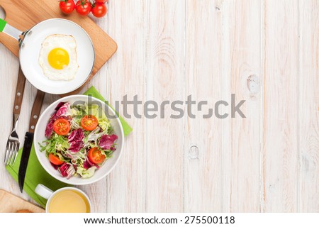 Healthy breakfast with fried egg, toasts and salad on white wooden table. Top view with copy space