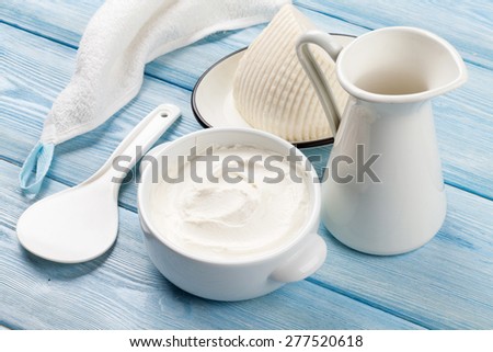 Dairy products on wooden table. Sour cream, milk and cheese