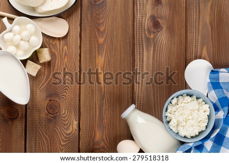 Dairy products on wooden table. Sour cream, milk, cheese, eggs, yogurt and butter. Top view with copy space
