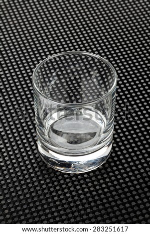 Empty whiskey glass on black rubber mat
