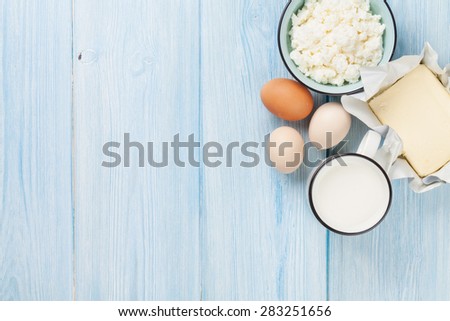 Dairy products on wooden table. Milk, cheese, egg, curd cheese and butter. Top view with copy space