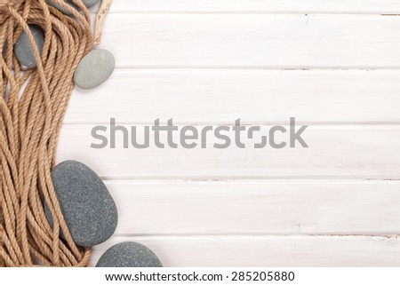 Wooden background with marine rope, sea stones and copy space