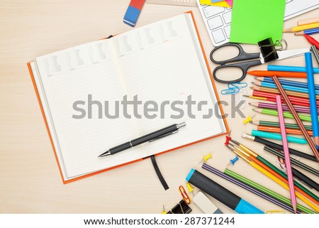 School and office supplies over office table. Top view with notepad for copy space