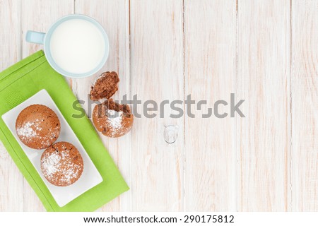 Cup of milk and cakes on white wooden table. Top view with copy space
