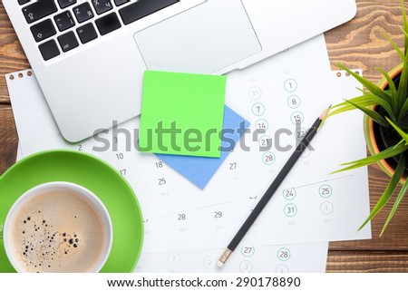 Office desk table with computer, supplies, flower and coffee cup. Top view