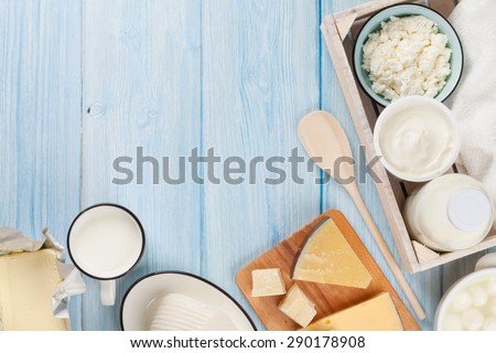 Dairy products on wooden table. Sour cream, milk, cheese, egg, yogurt and butter. Top view with copy space