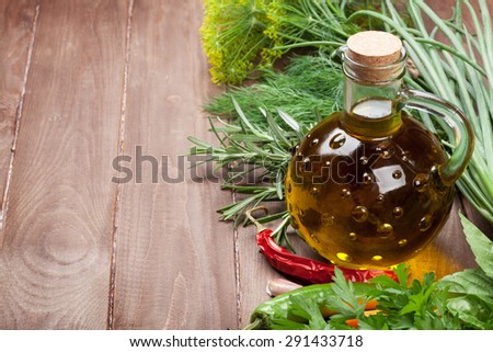 Fresh garden herbs and olive oil on wooden table. View with copy space