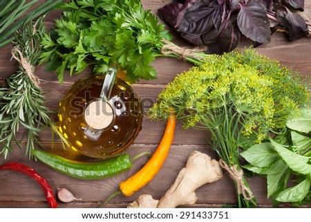 Fresh garden herbs and olive oil on wooden table. Top view