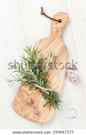 Fresh garden rosemary and garlic on cutting board. Top view