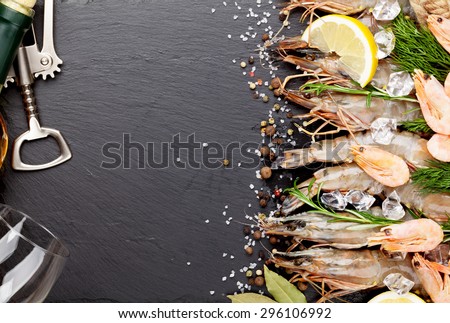Fresh prawns with spices and white wine on black stone background. Top view with copy space