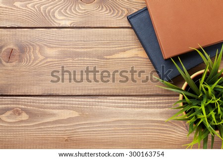 Office desk table with flower and notepad. Top view with copy space