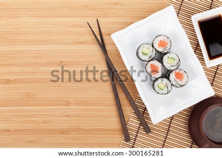 Sushi set, chopsticks and soy sauce over bamboo table with copy space