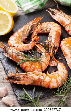 Grilled shrimps on stone plate over wooden table
