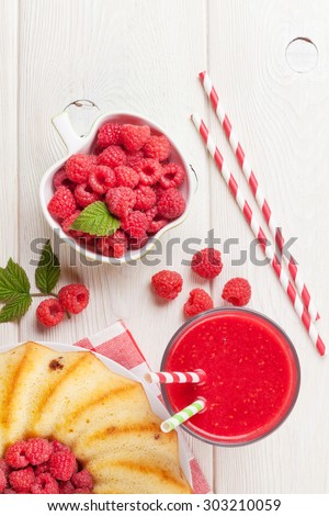 Raspberry smoothie, cake and berries on wooden table. Top view