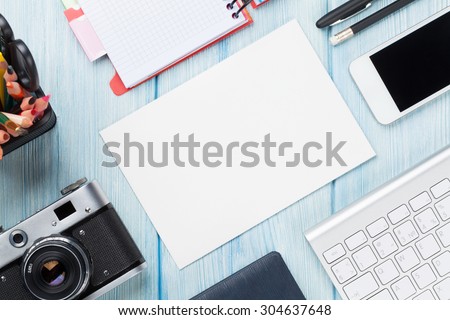 Office desk with supplies, camera and blank card. Top view with copy space