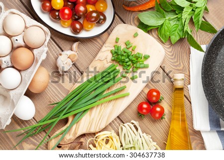Pasta cooking ingredients and utensils on wooden table. Top view