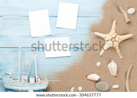 Travel and vacation photo frames and items on wooden table. Top view