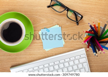 Blank post-it with office supplies and coffee cup on wooden table. Above view