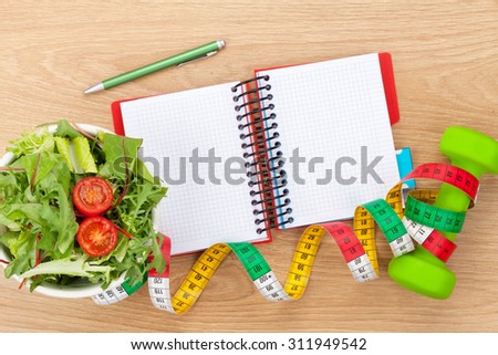 Dumbells, tape measure, healthy food and notepad for copy space. Fitness and health. Isolated on white background