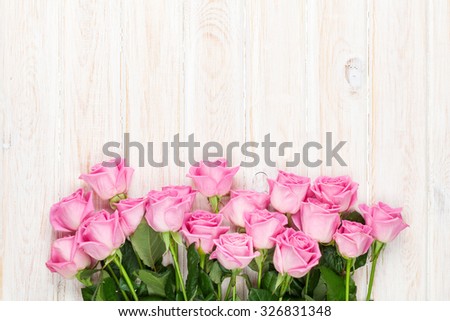 Pink roses bouquet over wooden table. Top view with copy space
