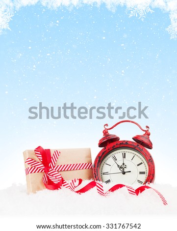 Christmas gift boxe and alarm clock in snow with copy space