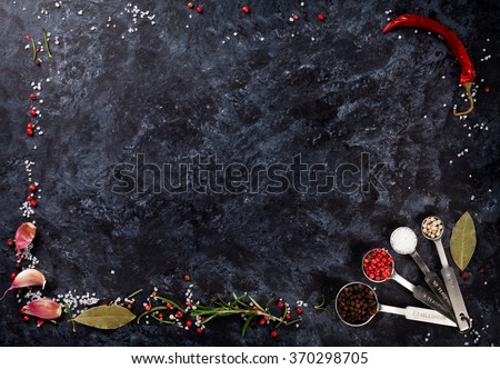 Herbs and spices frame over black stone background. Top view with copy space