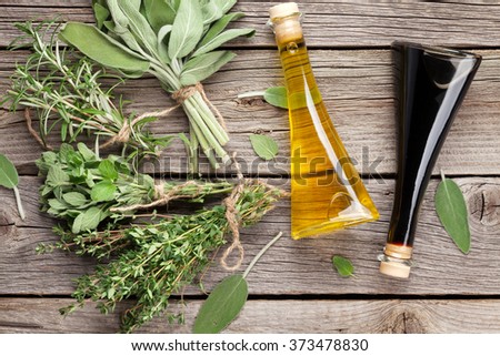 Fresh garden herbs and condiments on wooden table. Top view