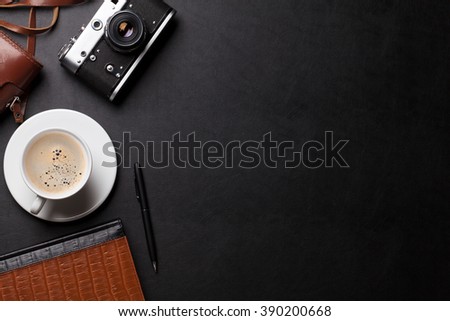 Office desk with photo camera, coffee and notepad. Top view with copy space