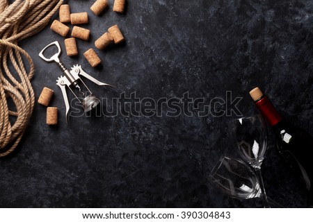 Wine, glasses and corkscrew over stone background. Top view with copy space