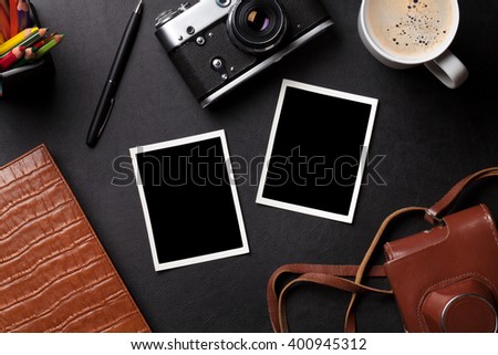 Office desk with photo frames, camera, coffee and notepad. Top view with copy space
