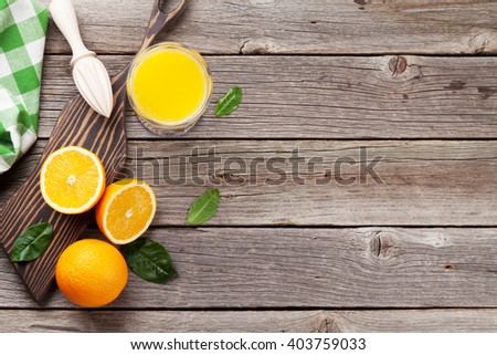 Fresh ripe oranges and juice on wooden table. Top view with copy space