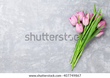 Fresh pink tulip flowers on stone table. Top view with copy space