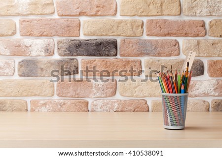 Office desk workplace table in front of brick wall. View with copy space