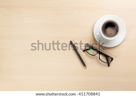 Office desk table with coffee cup, pen and glasses. Top view with copy space. Business office desk overhead view