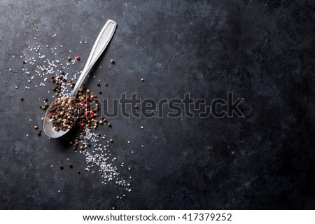 Black, white and red pepper and salt in spoon. Classic mixed spices for cooking. Top view with copy space