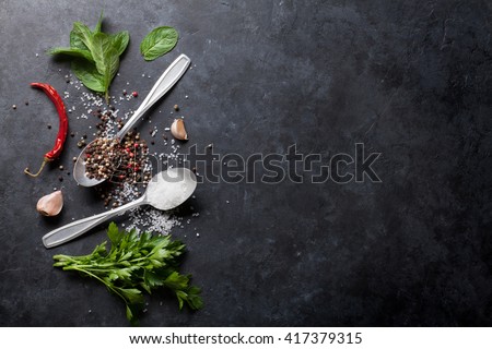 Black, white and red pepper and salt spices in spoon. Mint and parsley herbs. Classic mixed spices for cooking. Top view with copy space for your recipe