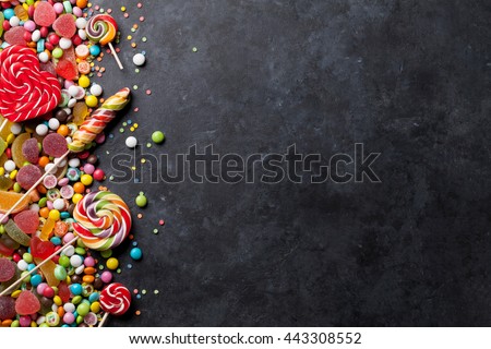 Colorful candies, jelly and marmalade over stone background. Top view with copy space