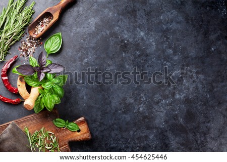 Herbs and spices cooking on stone table. Basil, rosemary, pepper and salt. Top view with copyspace